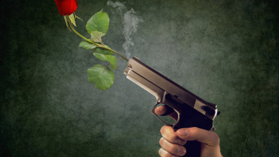 Peaceful act. Pistol and red rose